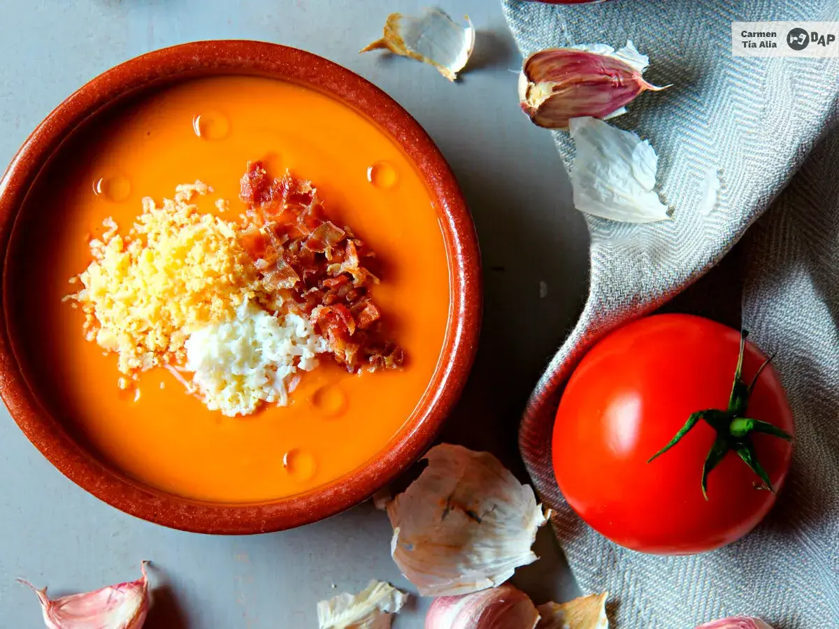 Salmorejo cremoso hecho en Thermomix, servido en cuenco de barro con huevo duro picado y taquitos de jamón.