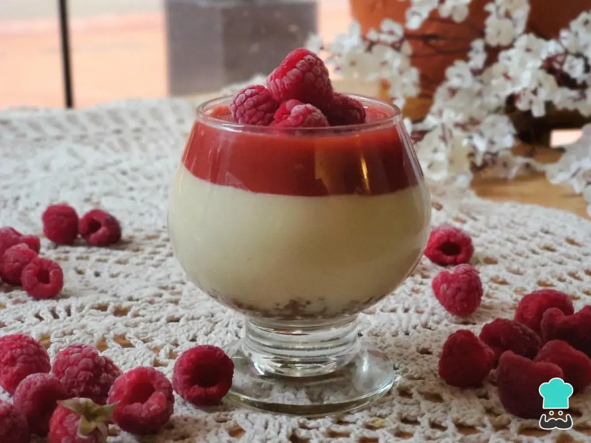 Deliciosa tarta de queso sin horno en copa, coronada con frambuesas frescas y coulis de frutos rojos.