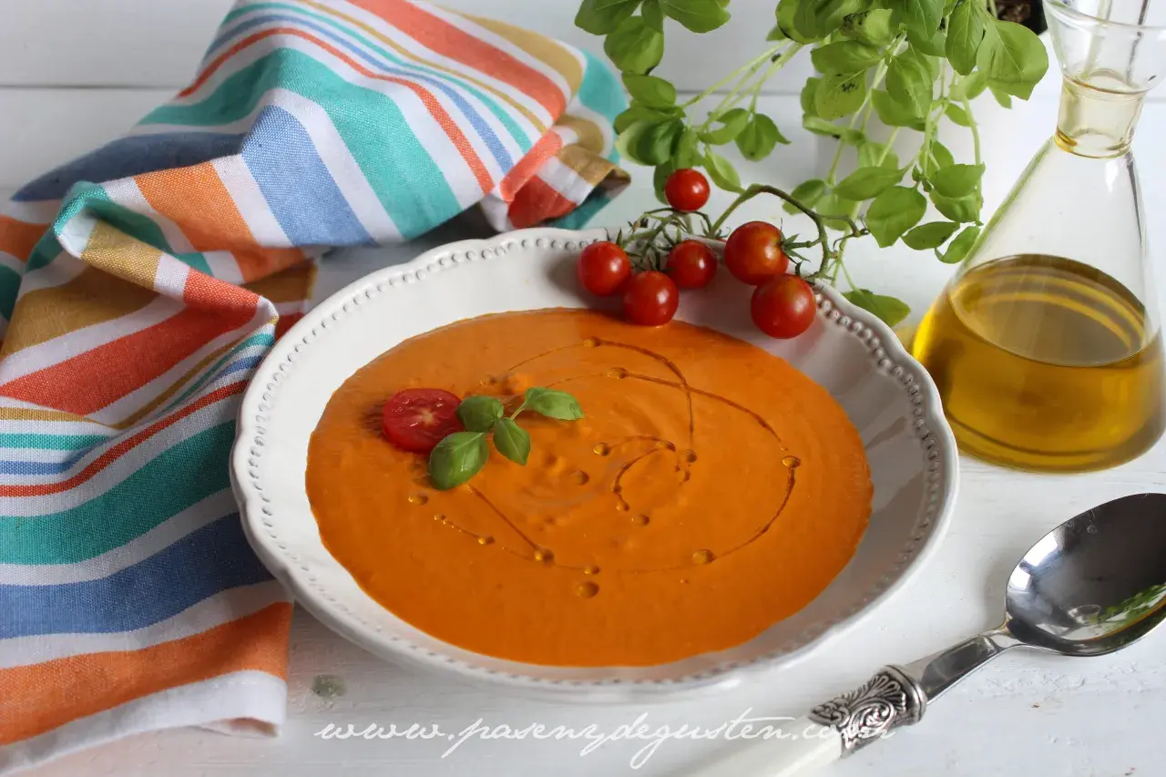 Crema de queso de tomate, decorada con tomates cherry y albahaca, lista para disfrutar.