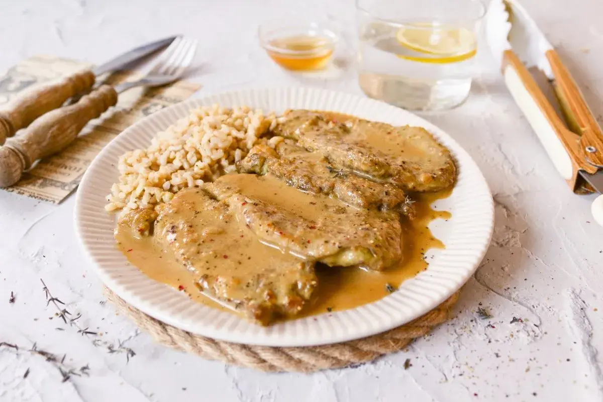 Escalopines de ternera en salsa cremosa con arroz. Un plato delicioso y reconfortante.