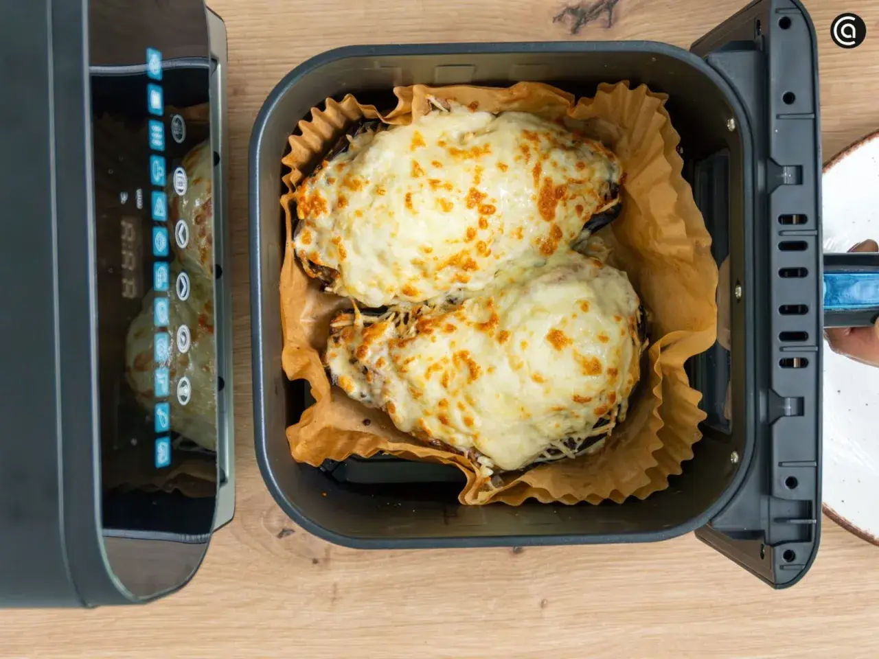 Dos berenjenas rellenas gratinadas con queso dorado, listas para disfrutar tras su paso por la airfryer.