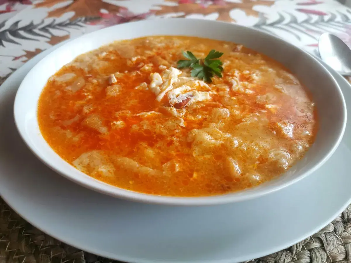 Un plato humeante de sopas de ajo receta, con huevo escalfado y perejil fresco.