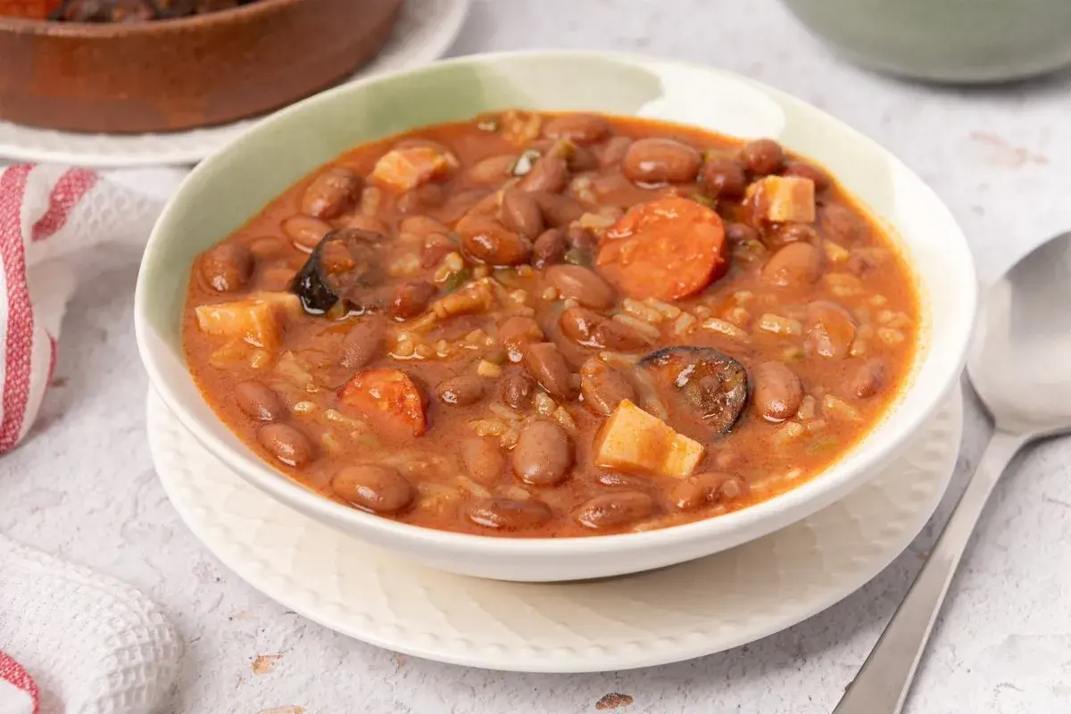 Un tazón humeante de alubias pintas con chorizo, patatas y arroz. Un plato reconfortante y sabroso.
