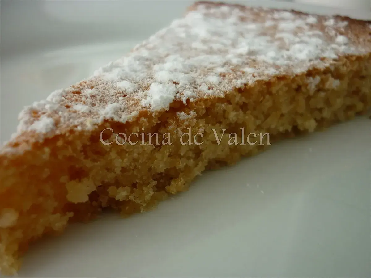 Rebanada de tarta de almendras esponjosa, espolvoreada con azúcar glas. ¡Un bocado delicioso!