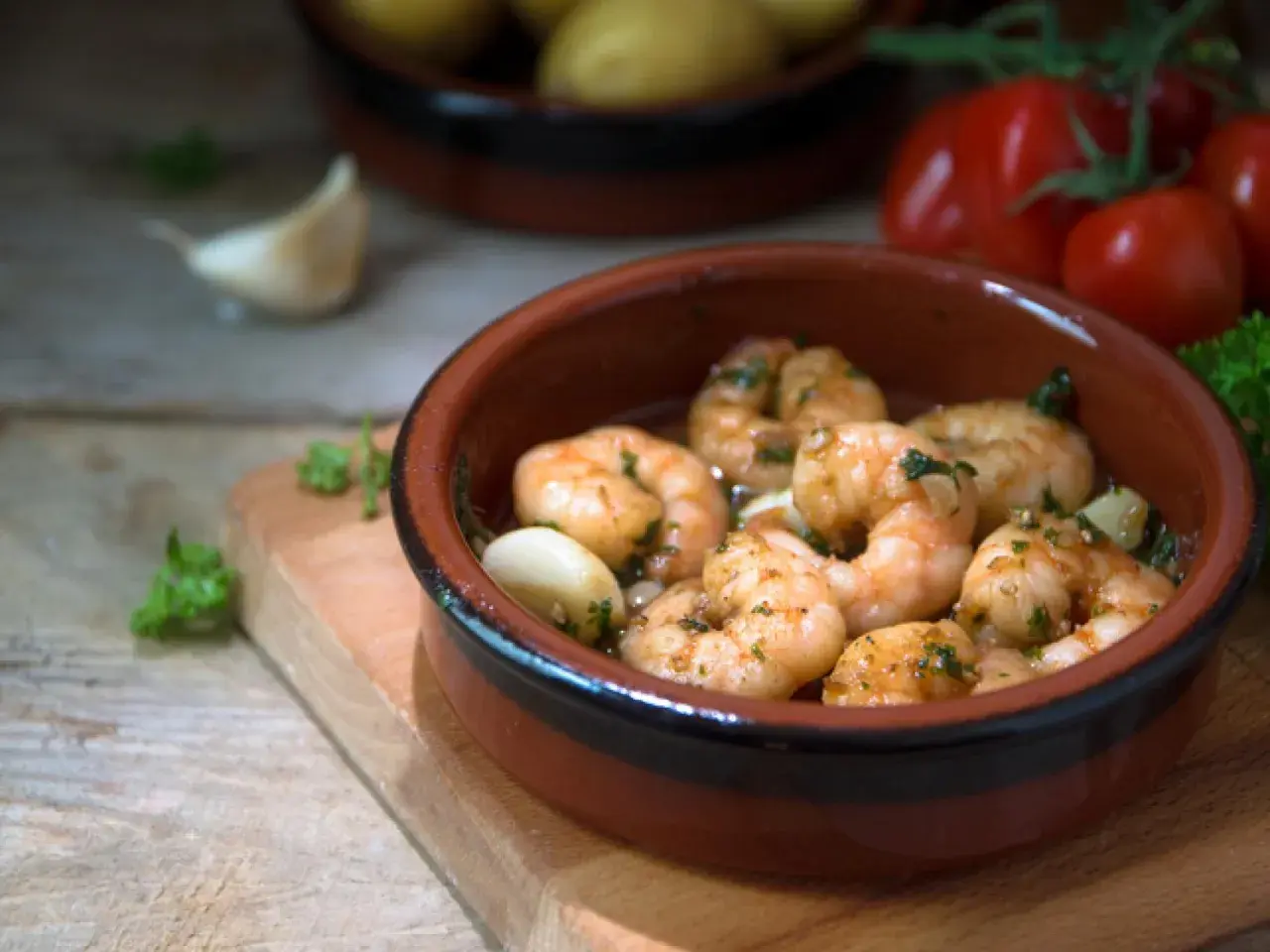 Deliciosos langostinos al ajillo, servidos en cazuela de barro con ajo y perejil.