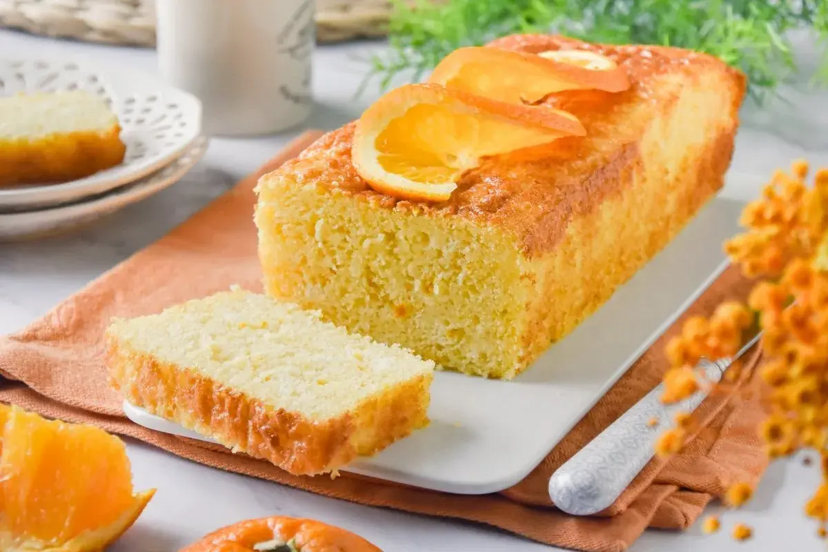 Un delicioso bizcocho de naranja, con rodajas de naranja fresca en la parte superior, listo para ser disfrutado.