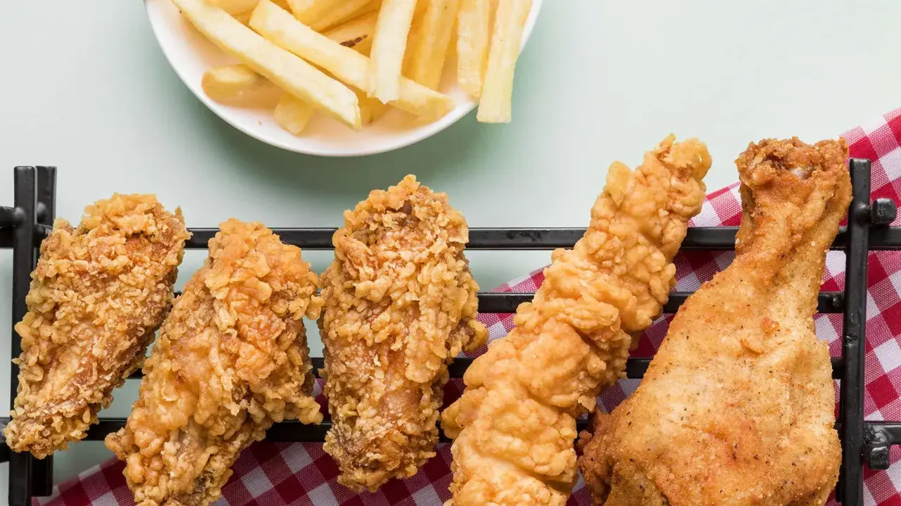 Crujientes alitas de pollo fritas y papas fritas doradas, un festín irresistible para cualquier amante de la comida rápida.