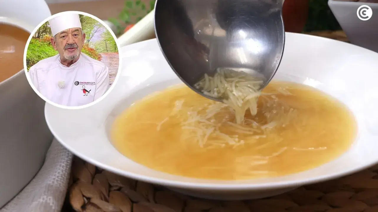 Un chef sirve sopa de fideos en un plato blanco. El caldo dorado y los finos fideos se ven deliciosos.