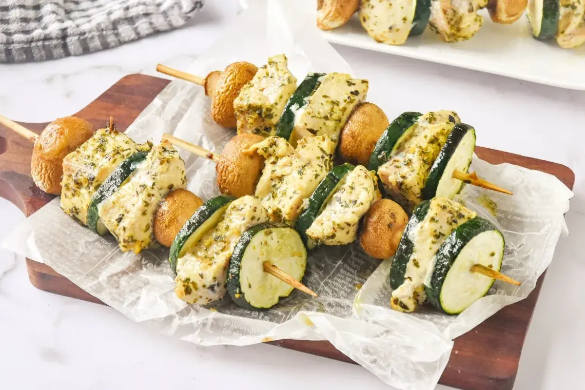 Brochetas de pollo marinadas con calabacín y champiñones, listas para asar.