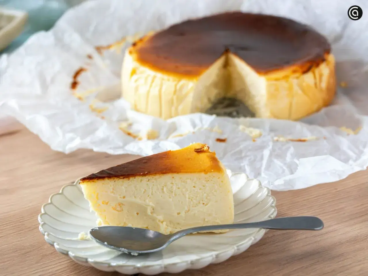 Deliciosa tarta de queso en freidora de aire, con una porción servida en plato y cuchara.