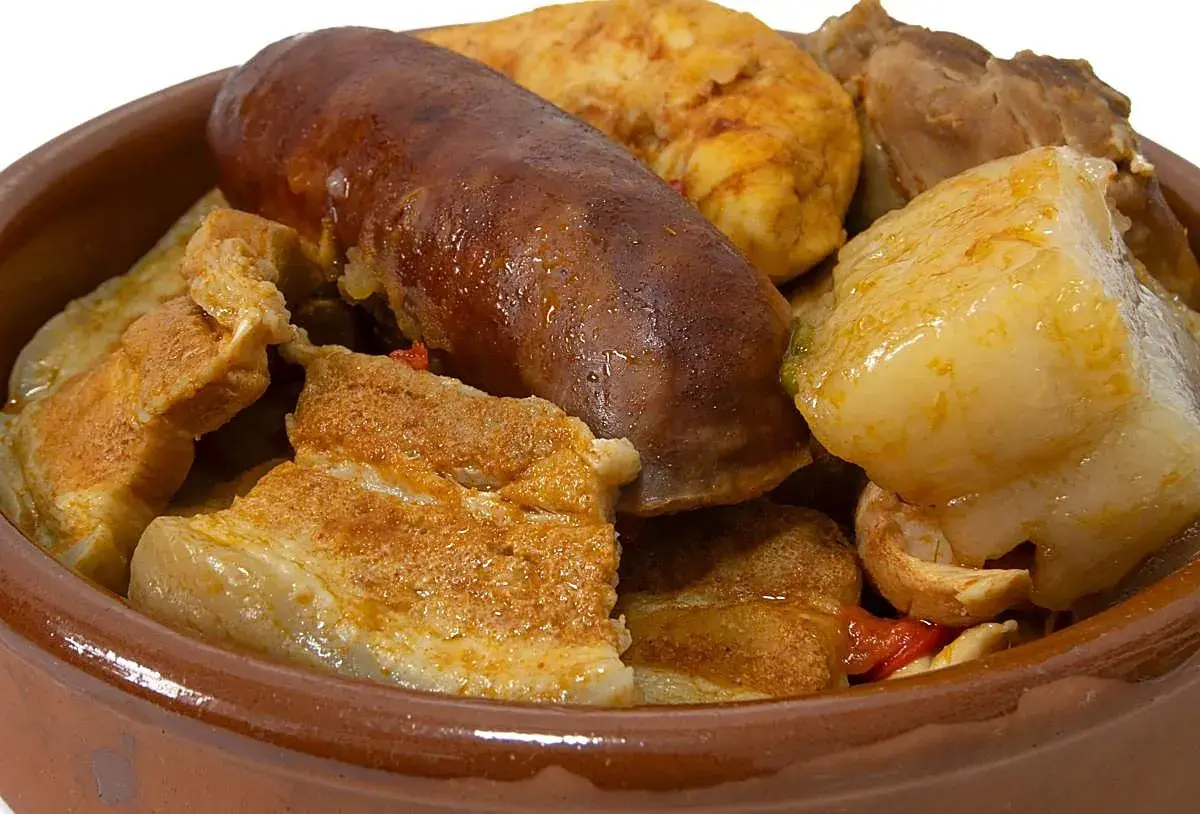Un reconfortante puchero andaluz en cazuela de barro, con chorizo, tocino y trozos de carne.