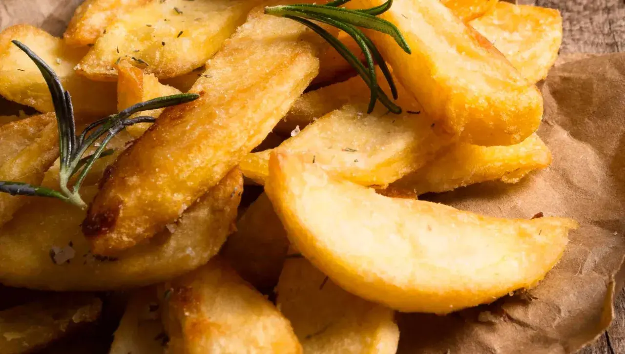 Patatas fritas crujientes y doradas hechas en airfryer, con romero fresco y sal. ¡Un aperitivo saludable y delicioso!
