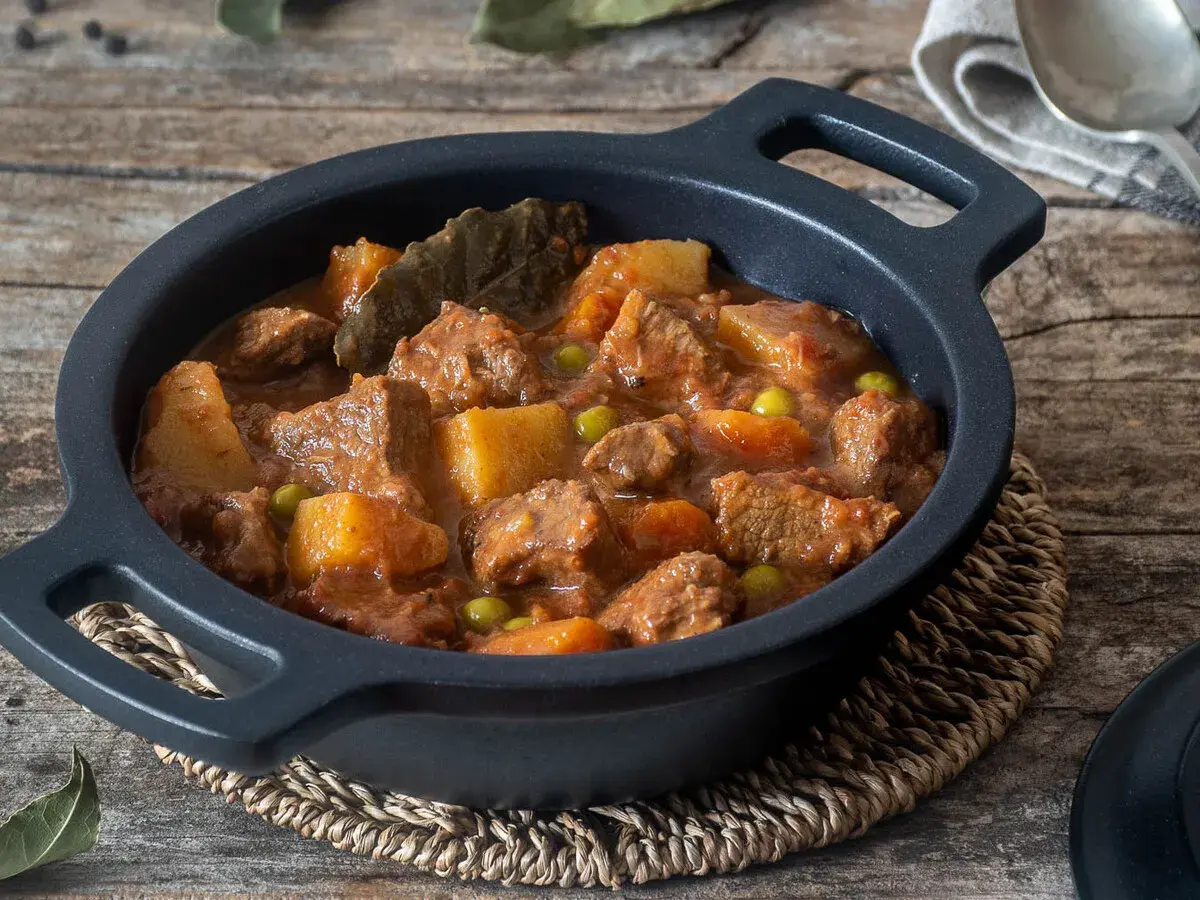Un reconfortante estofado de ternera de la abuela, con trozos tiernos de carne, patatas y guisantes en una rica salsa.