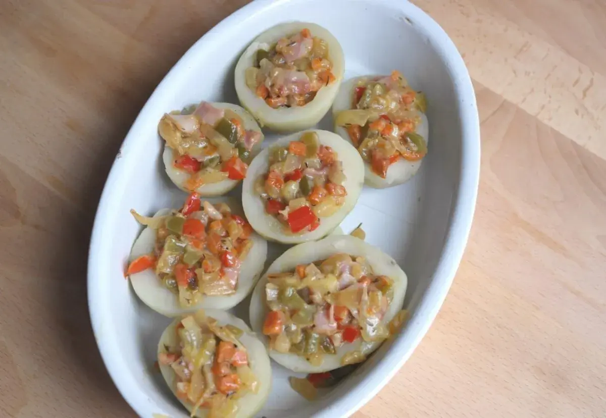 Patatas rellenas con verduras y jamón, listas para hornear. Un plato casero y delicioso.