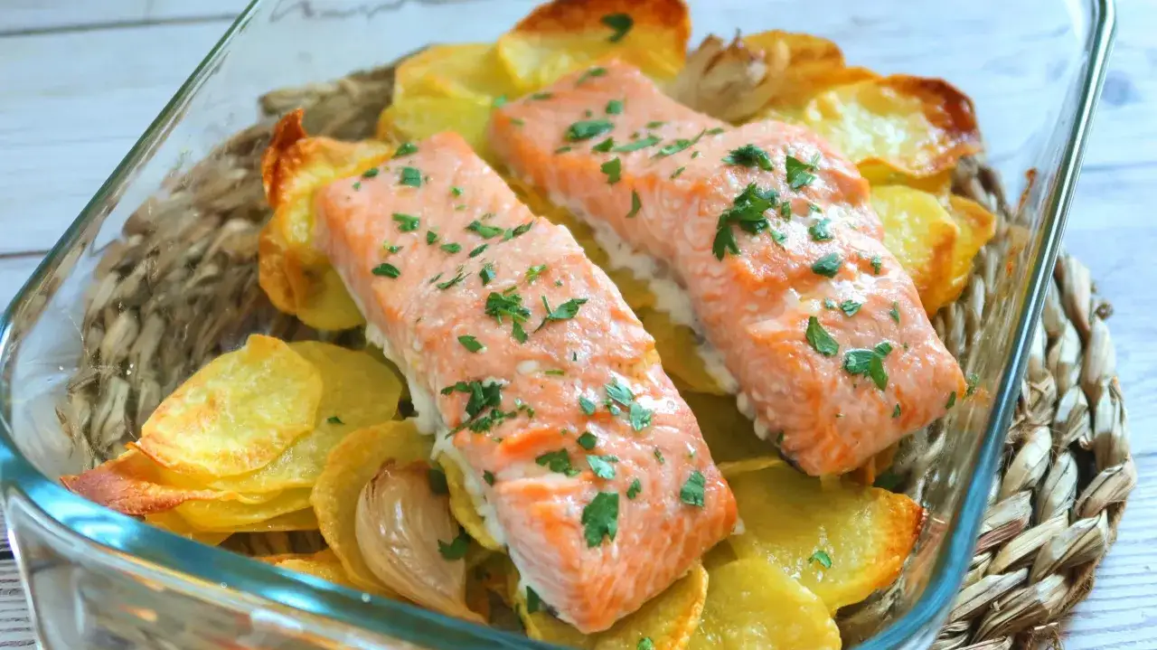 Dos filetes de salmón horneados sobre patatas crujientes, una de las mejores recetas con salmón.
