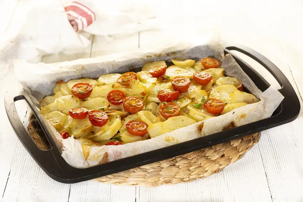 Patatas al horno con tomates cherry, doradas y sabrosas, listas para disfrutar.