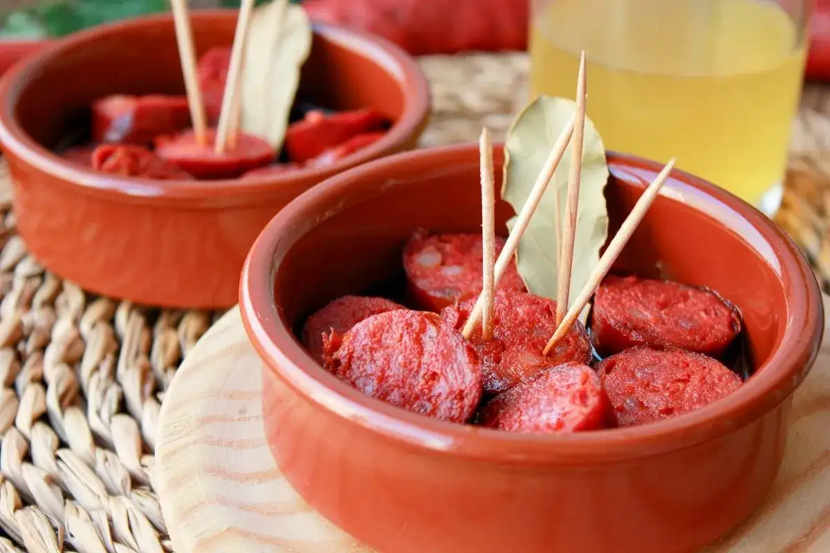Dos cuencos de barro con chorizos a la sidra, listos para disfrutar.