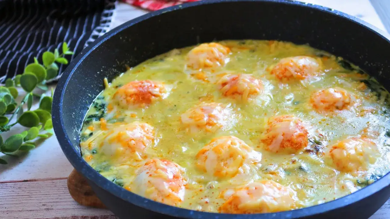 Deliciosos espinacas a la crema gratinadas con queso en una sartén.