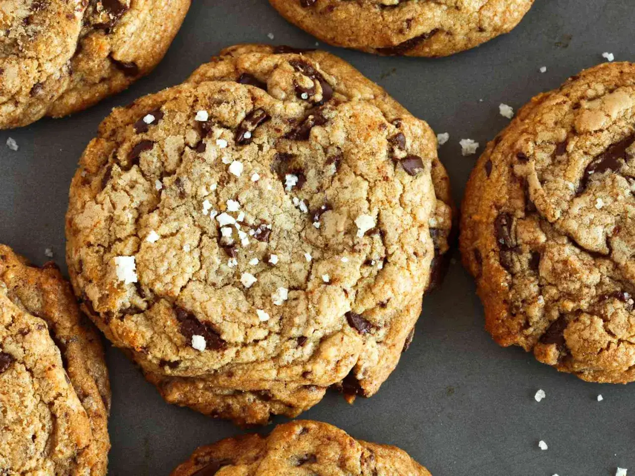 Galletas de chocolate recién horneadas, doradas y crujientes, con trozos de chocolate derretido y un toque de sal marina.