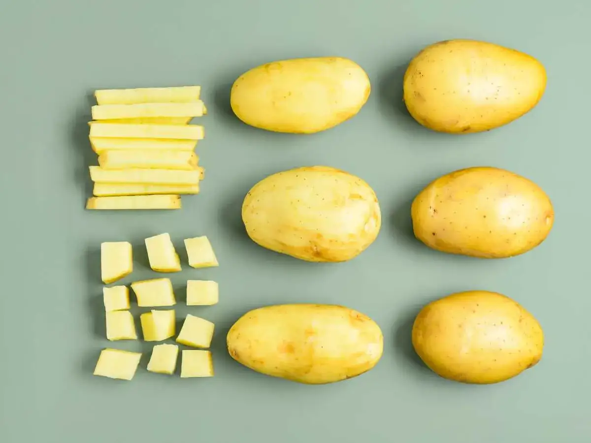 Patatas enteras, cortadas en bastones y en cubos, listas para cocer.