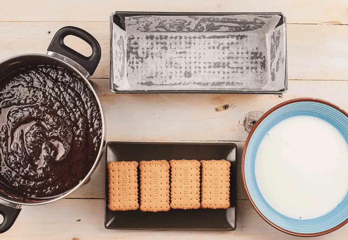 Ingredientes para la tarta de galletas de la abuela: chocolate derretido, galletas, molde y leche.