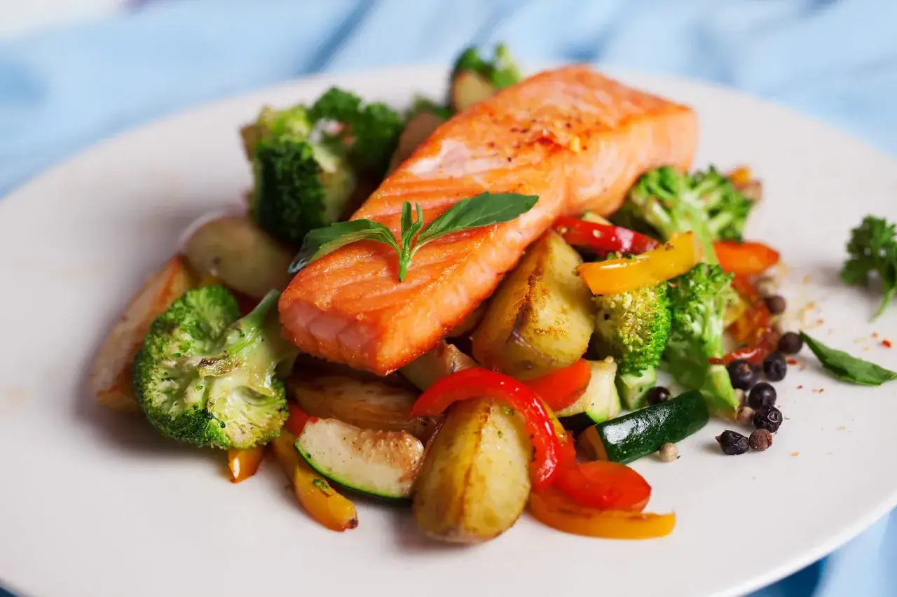 Delicioso salm&oacute;n al horno con papas, br&oacute;coli, pimientos y calabac&iacute;n, un plato saludable y lleno de sabor.