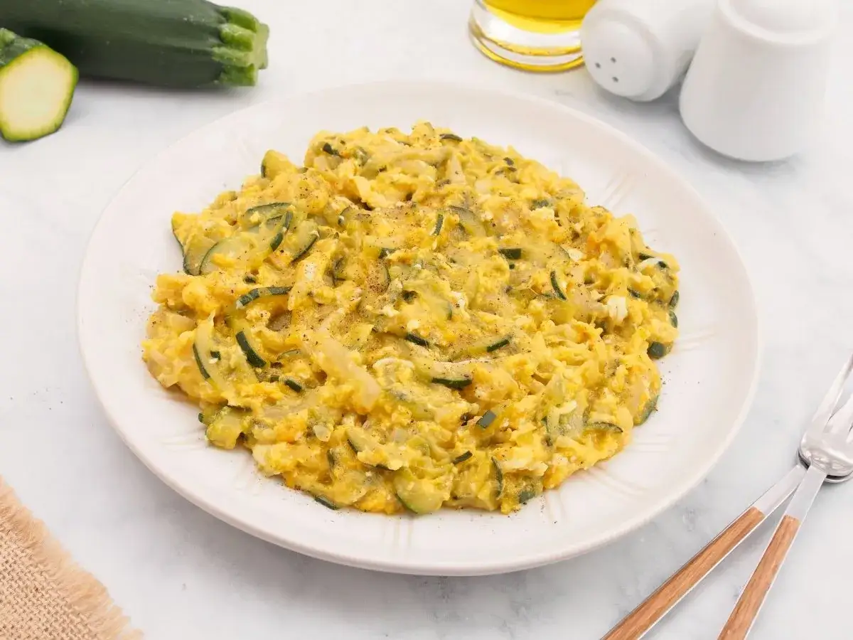 Zarangollo murciano, un plato casero de calabacín y huevo, servido en un plato blanco.